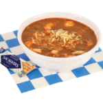 Image of a shrimp gumbo bowl with crackers on a blue and white checkered paper