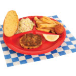 1 PC Grilled Crab Cake Plate with french fries, colelsaw, garlic bread, hush puppy, slice of lemon plated on a red plate on top of a white and blue checker paper